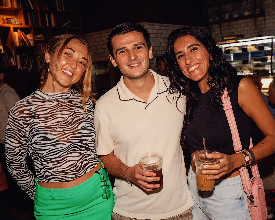 Three friends laughing together at the bar